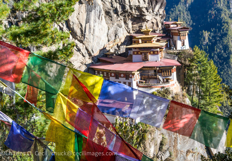 Paro, Bhutan. Tiger's Nest Monastery, Prayer Flags in Foreground. Reached after a hike of 4-5 hours from the trailhead, the monastery is at an altitude of just over 10,000 feet.