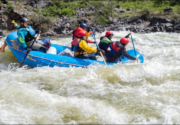 Guide Daniela Stokes expertly guides her paddle raft through boiling whitewater rapids.