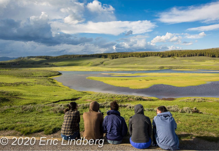 Visitors scan distant hills for evening wildlife in Yellowstone National Park.