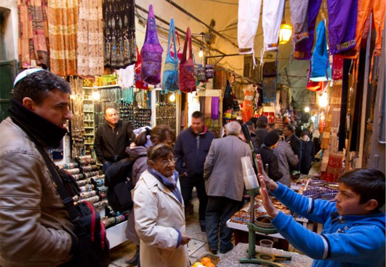 A young shopkeeper in the Arab souk (market) section of the Muslim Quarter bargains with a potential customer over the price of pomegranates.