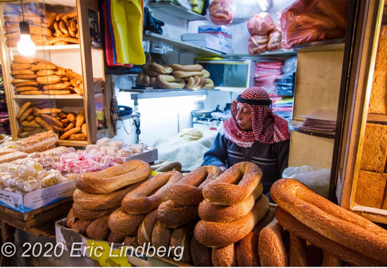 An Israeli Arab wearing a keffiyeh headscarf sells bread from his shop in the Moslem quarter.