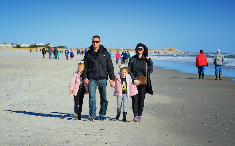 Family walking on sparsely populated beach