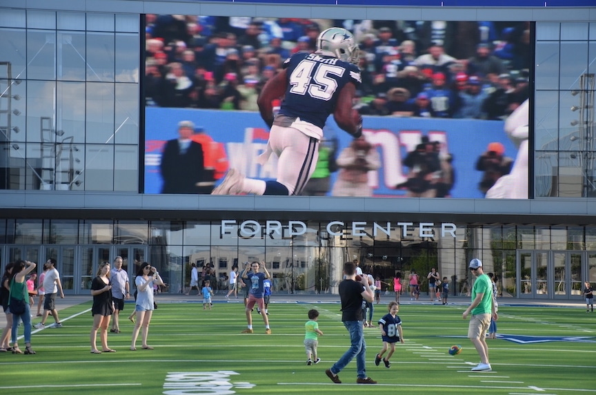 Fan throw footballs at a Ford Center field set aside for tourists in Frisco, TX