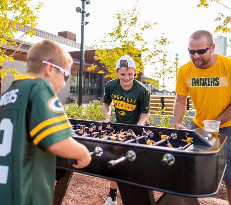 Family plays foosball before the pros play football