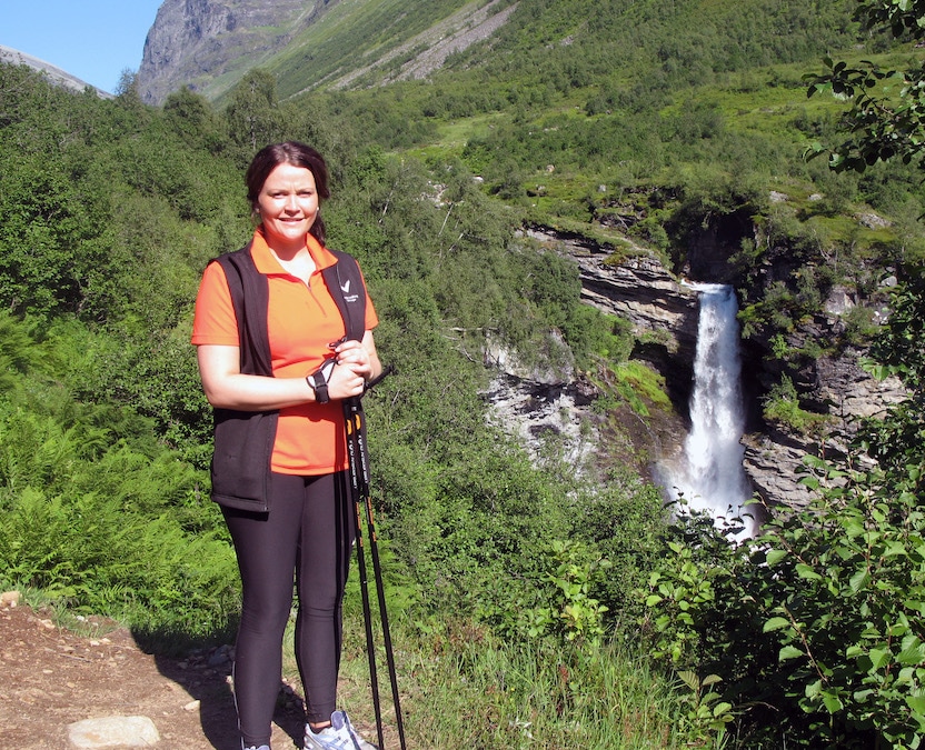 A fellow Nordic walker poses at the waterfall