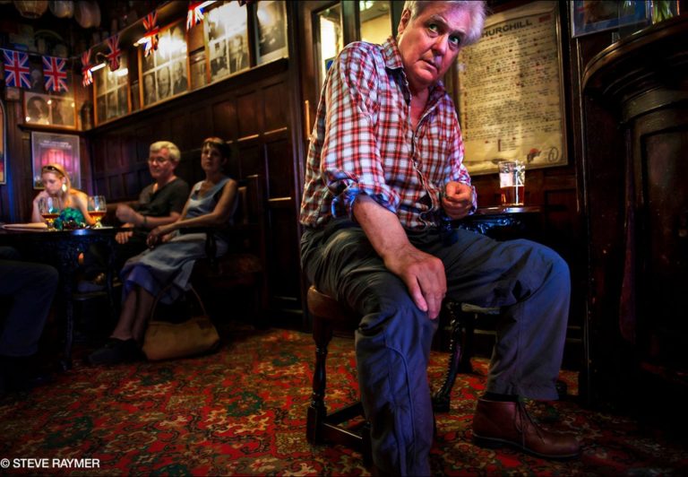 Man-sitting-at-small-table-with-beer
