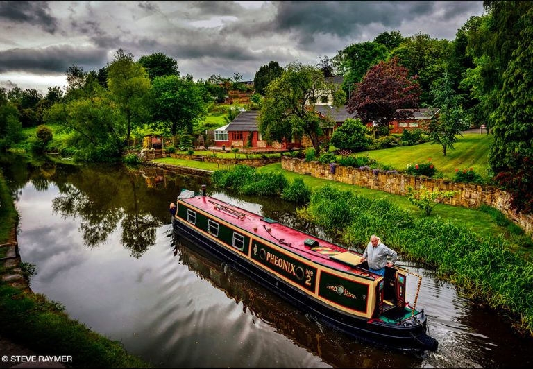 Man-standing-on-house-boat-in-the-river