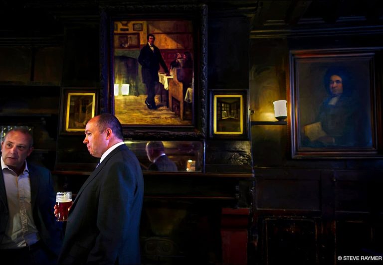 Two-men-talking-in-front-of-paintings