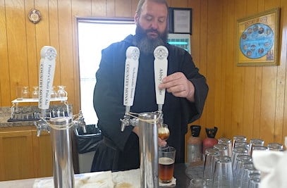 Br. Sebastian Richey pouring from a selection of stouts and ales that he made at the Abbey copy
