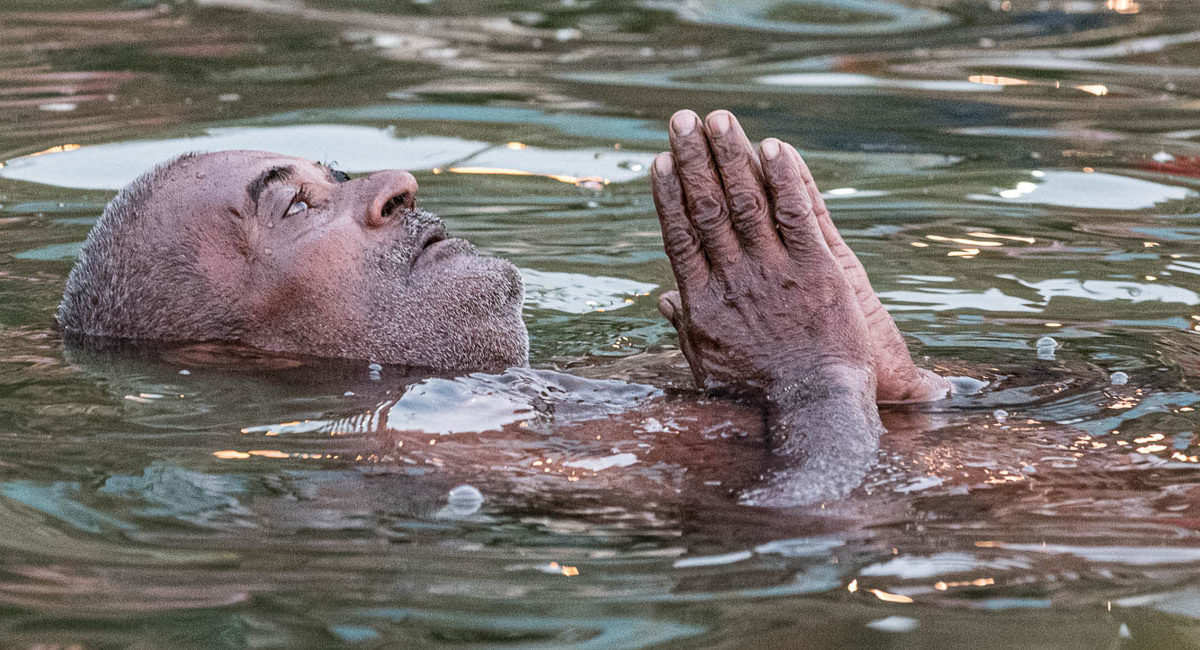 Varanasi, India by Donnie Sexton Man praying in the Ganges River