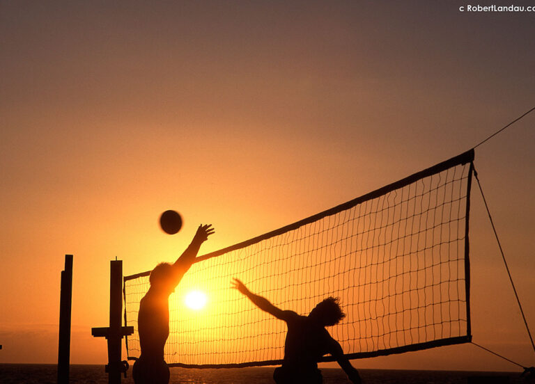 beach volleyball players at sunset