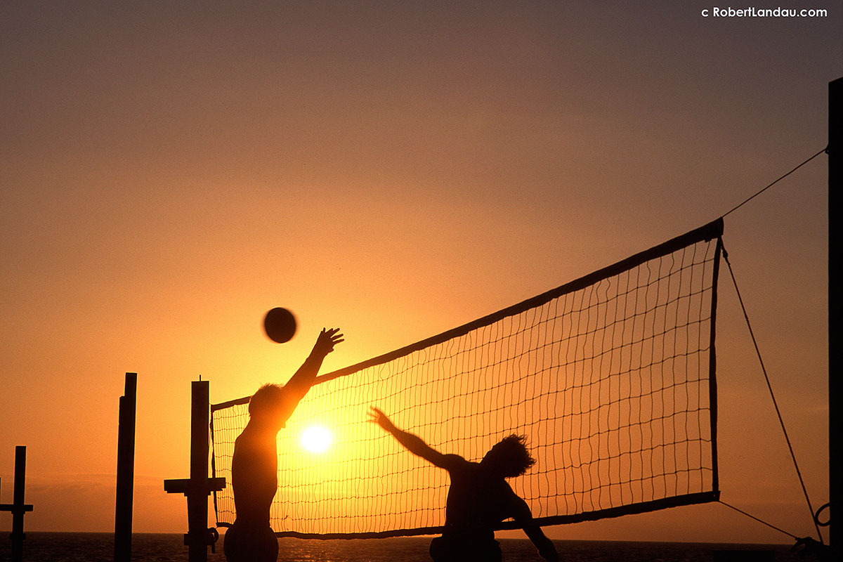 beach volleyball players at sunset