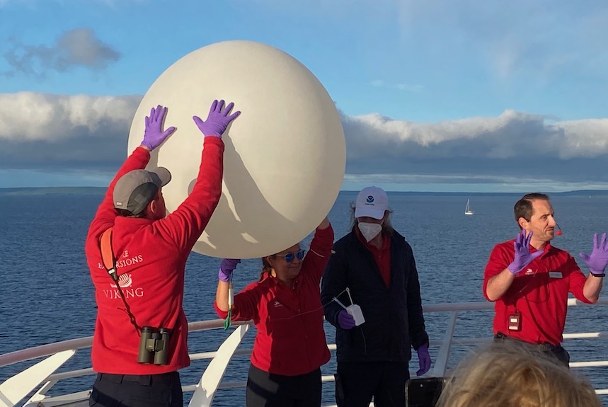 Viking scientists prepare to launch a weather balloon early one morning as passengers gathered to watch. Viking has a partnership with NOAA.