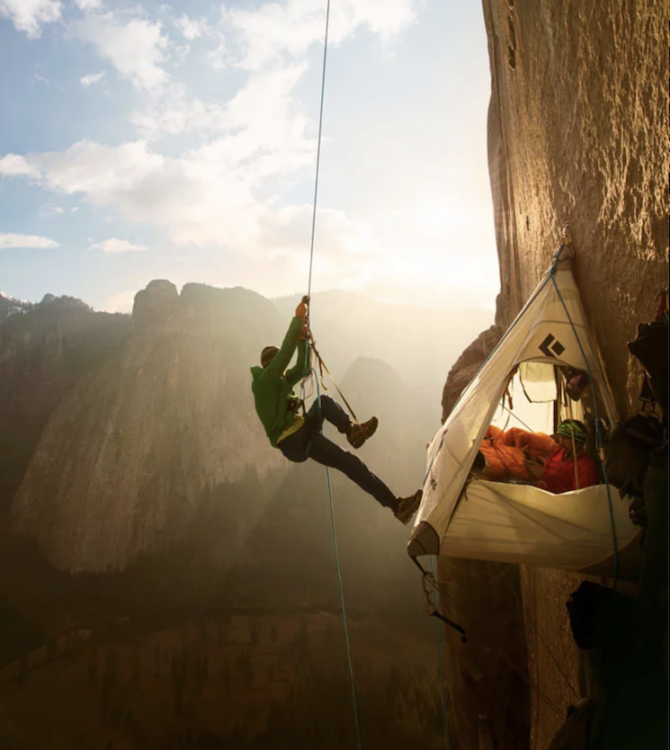 Tommy Caldwell hangs from a rope while Kevin Jorgansen relaxes in a tent while climbing El Capitan's Dawn Wall in Yosemite National Park.