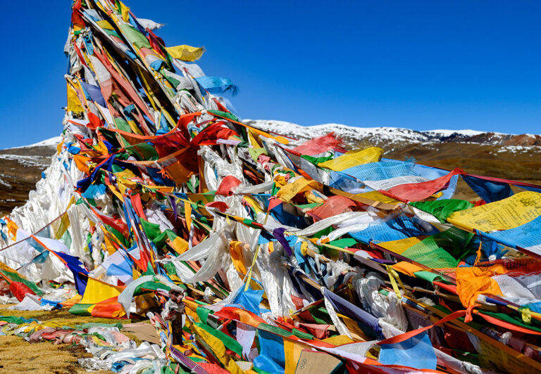 At Gyatso la Pass, thousands of prayer flags flutter in the ever-present wind. Guides typically carry a bundle of flags and distribute them to the group so everyone can add a flag with their prayer or blessing if they wish.