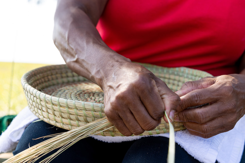 A member of Sapelo Island’s Gullah-Geechee community weaves a basket made of sweetgrass. Photo courtesy of Ben Galland