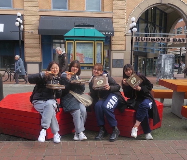 Tourists eating pizza in downtown Victoria, BC