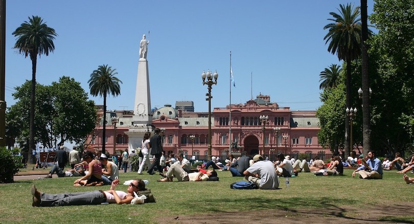 On a sunny Spring Day in Buenos Aires, citizens relax on the grass in Bolivar Square in front of the Casa Rosada Presidential residence.