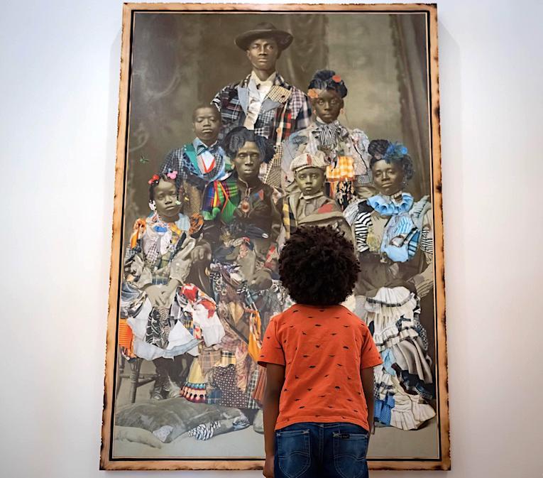 Child looking at an historic portrait of a black family hanging inside Charleston's International African American Museum.