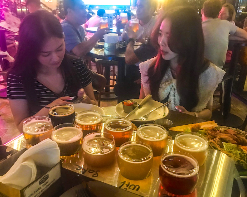 Two Vietnamese women sample ten beers at the East West Brewing Company in Saigon.