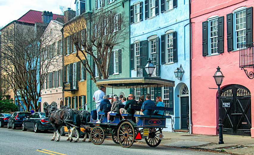 Horse drawn carriages providing relaxing tours of Charleston often pause near Rainbow Row.