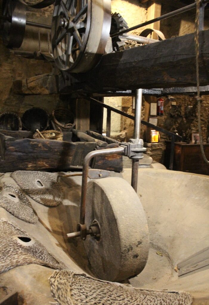 A stone wheel once used for crushing olives is now a centerpiece exhibit in the Molino del Medio museum.