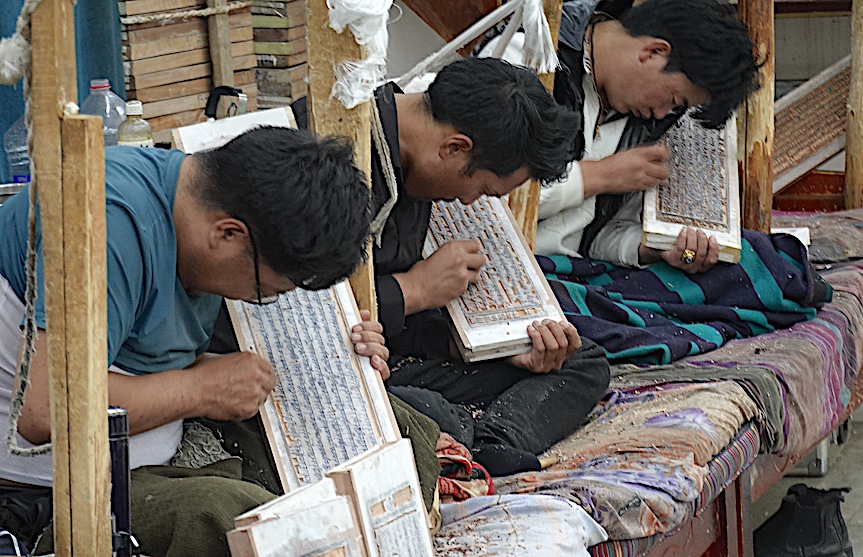 Student artisans at the Shoe Dulpal Tibetan Handicraft School in Lhasa employ traditional methods to incise Buddhist sutras on wooden panels intended for use by praying monks in monasteries. 