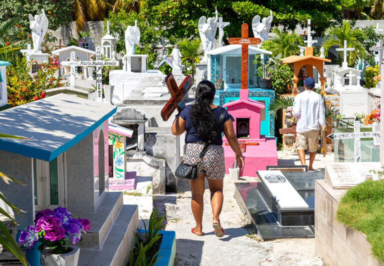A local resident carrying a cross arrives at the city cemetery to arrange a graveside offering. Cemetery crypts are above ground because of a high water table