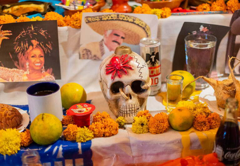 An ofrenda is an offering of personal mementos of a deceased person. Skulls made of sugar candy, photographs, drinks and favorite foods are displayed on an altar.
