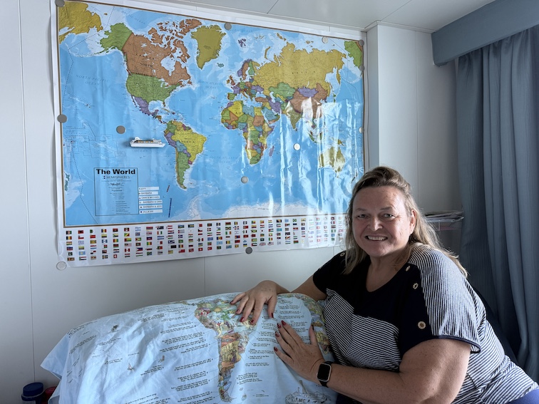 Barbara Violetta with her world map in her Odyssey villa.
