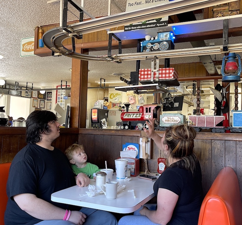Fritz's famous hamburgers are delivered by model railroad locamotives to hungry diners.