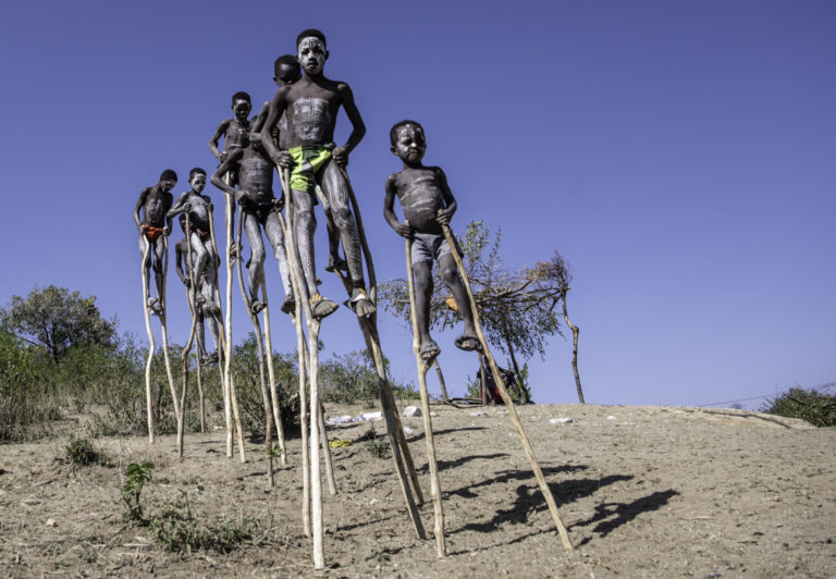 During the drive to Turmi, a group of boys from the Bana tribe appeared alongside the highway. With faces and bodies painted in white caulk paste, they move around on very long stilts. They were agreeable to having their photos taken but appreciated a small tip in exchange.