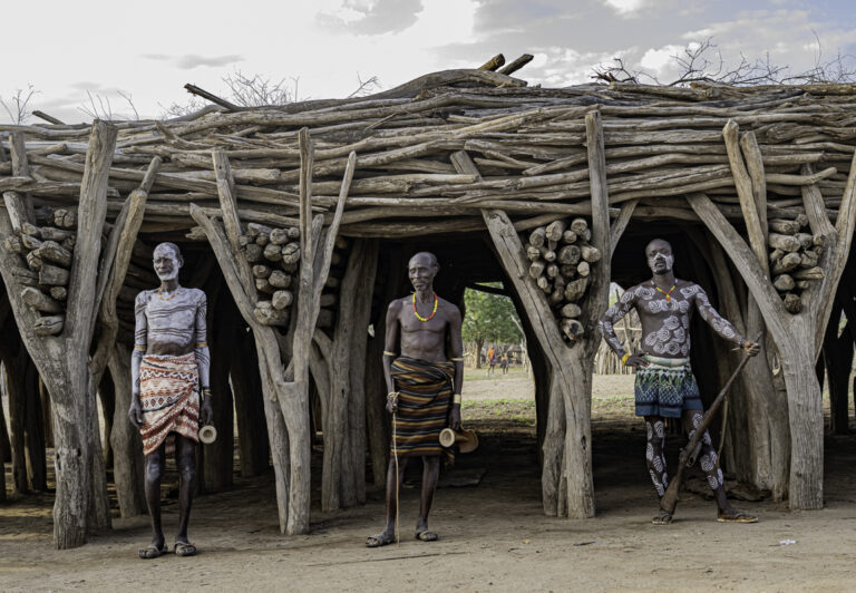 The Kara ethnic group lives near the Omo River, where they have access to water for growing crops and for fishing. The men are known for their elaborate body painting, which uses white caulk made into a paste.