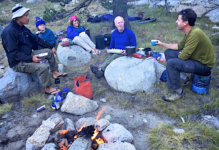 Hikers enjoy a campfire and dinner in Yosemite.