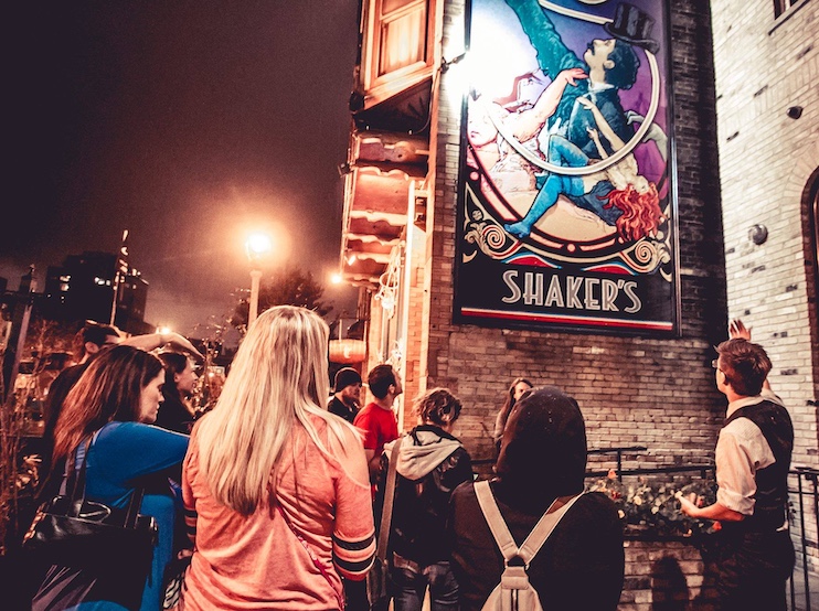 Women on a cannibal tour of Milwaukee neighborhoods effected by serial killer Jeffrey Dahmer, pause outside Shakers, a bar that Dahmer frequented. 