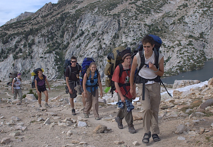 A group of young hikers ascends a pass in Sierra National Forest. 