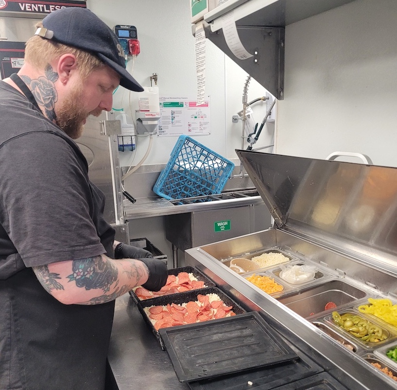 Detroit co-owner Nate Peck preparing pizza at Michigan & Trumbull.