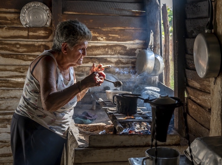 A farmer’s wife prepares coffee in their simple kitchen in Vinales.
