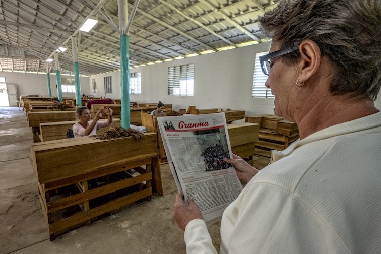 A tobacco factory "lectore" reads propaganda from "Granma," the official newspaper of the Central Committee of the Communist Party of Cuba.