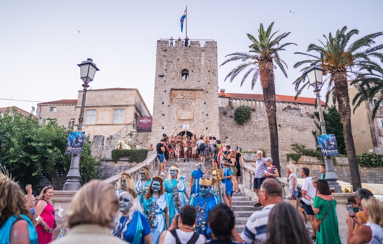 Revelers wearing colorful sea-themed costumes during Korčula Town’s Half New Year's Eve celebration in late June crowd the grand stairwell leading up to the Old Town. 