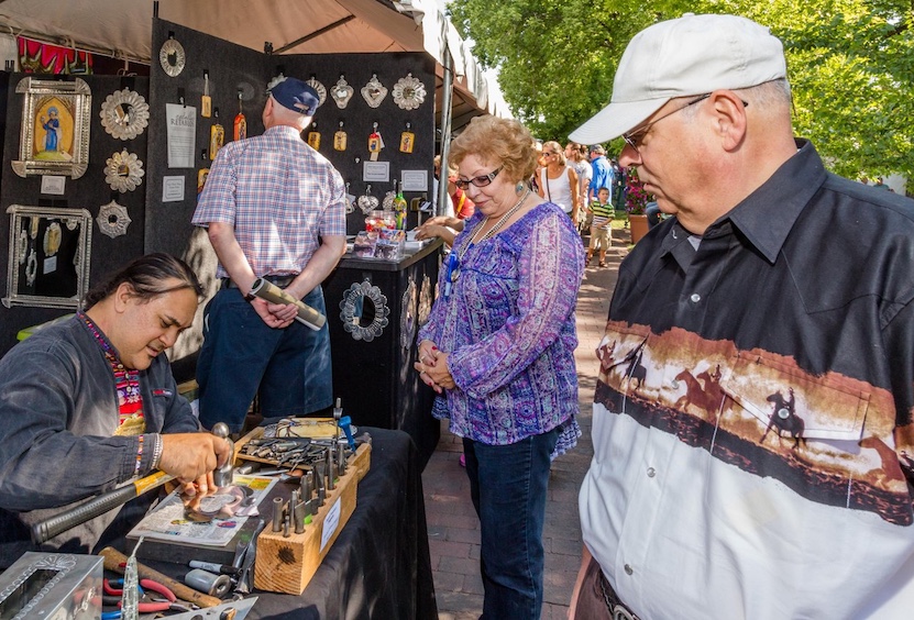 Tinsmith Jason Younis y Delgado demonstrates his craft at the Spanish Market in Albuquerque, New Mexico.