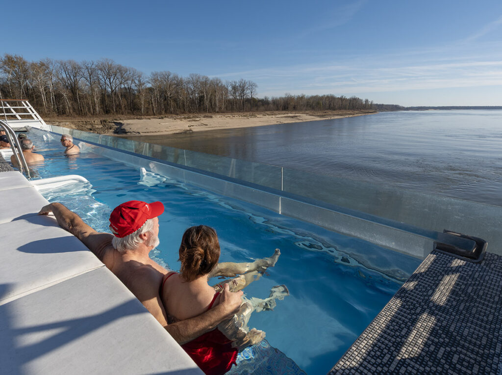 Guests enjoy the warm infinity pool on the top deck of the Viking Mississippi.