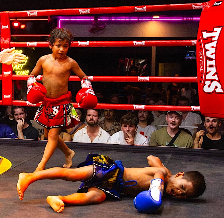 Goku paces around fallen foe Pingkong, who winces in pain as the Muay Thai crowd watches closely.