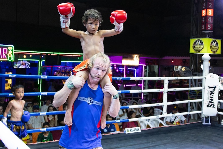 Sam Alexander carries his son, Goku, on his shoulders after the boy's three-round Muay Thai victory at the Loi Kroh stadium. 
