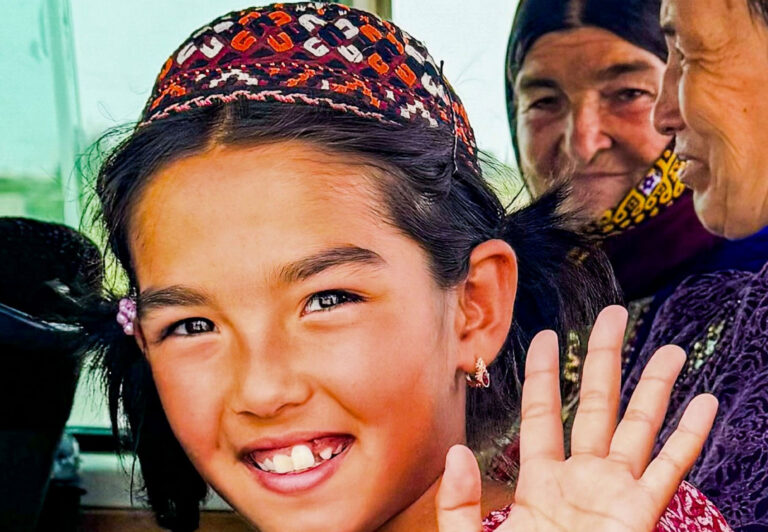In Turkmenistan, a young girl waves to travelers.