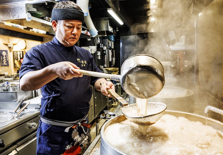 Ikkousha chef preparing a rich noodle soup.