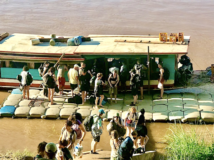 Western backpackers disembark the Mekong “slow boat” at Luang Prabang after a two-day voyage from tiny Houay Xai in the far north of Laos.