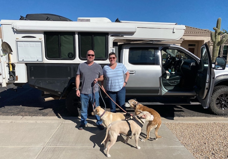 Gaylon Morris, his wife Chandra and their dogs pose in front of their truck camper, which makes a regular winter appearance in Quartzsite.