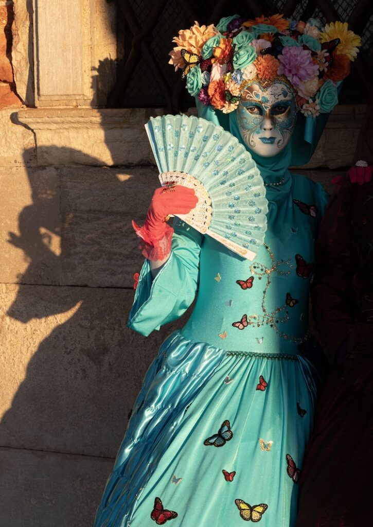 The warm low sun partially illuminates a flower adorned mystery woman, who knows how to throw a shadow. She is taking refuge from the crowds next the Doge’s Palace, by St. Mark’s Square.