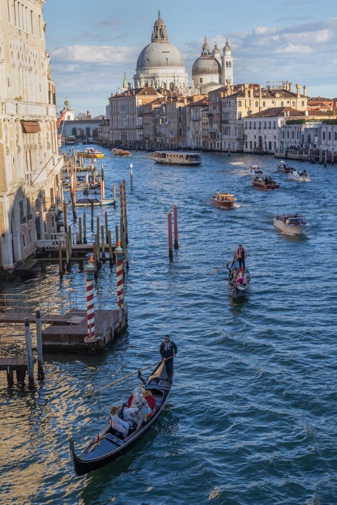 The other great bridge crossing the Grand Canal is the Accademia Bridge, the only one made wholly of wood. In the afternoon watch the parade of gondolas, opulent water taxis and vaporettos (water buses) cruising beneath it.
